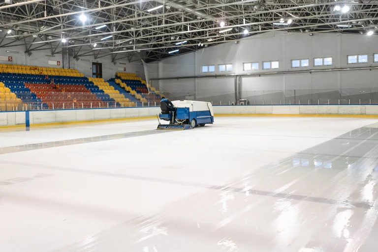 An ice resurfacer smoothing the surface of an indoor rink